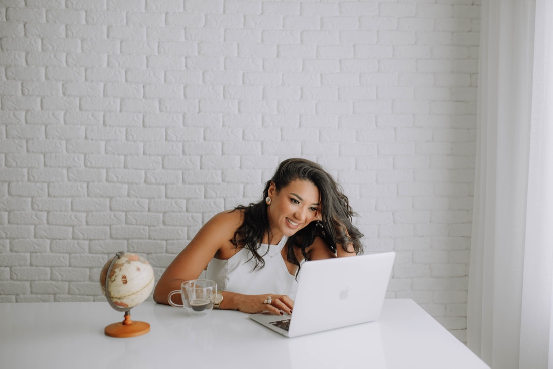 Dalvana Lopes en la mesa, con la laptop y un globo terráqueo